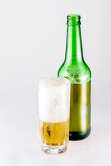 Bottle and glass of beer on a white background. Large malt cold drink. Studio photography on a white isolated background.