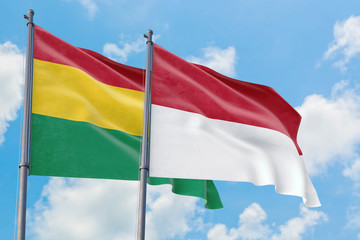 Monaco and Bolivia flags waving in the wind against white cloudy blue sky together. Diplomacy concept, international relations.