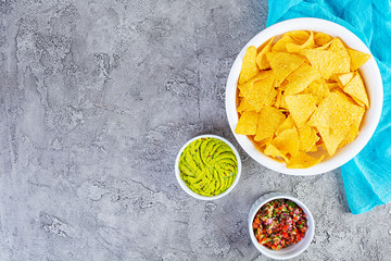 Mexican nachos with cheese. Corn chips with guacamole, salsa and tomato ketchup.