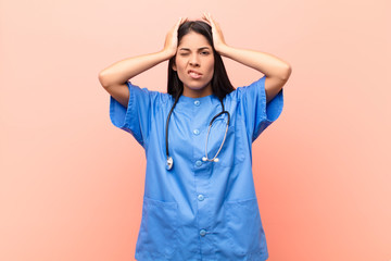 young latin nurse feeling frustrated and annoyed, sick and tired of failure, fed-up with dull,...