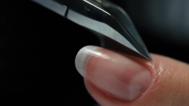 Careful removing of cuticle  with special cutter. A manicurist removes a cuticle from a client&rsquo;s nail. Manicure.