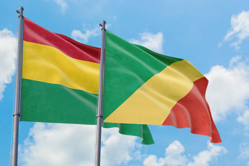 Republic Of The Congo and Bolivia flags waving in the wind against white cloudy blue sky together. Diplomacy concept, international relations.