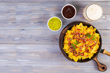 Mexican nachos with cheese. Corn chips with guacamole, salsa and tomato ketchup.