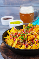 Mexican nachos with cheese. Corn chips with guacamole, salsa and tomato ketchup.