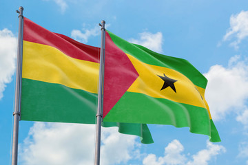 Sao Tome And Principe and Bolivia flags waving in the wind against white cloudy blue sky together. Diplomacy concept, international relations.