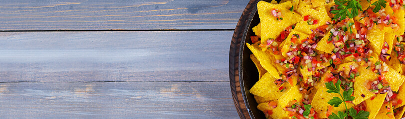 Mexican nachos with cheese. Corn chips with guacamole, salsa and tomato ketchup.