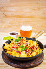 Mexican nachos with cheese. Corn chips with guacamole, salsa and tomato ketchup.