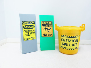 The Chemical Spill kit in yellow bucket and warning danger caution hazard tag sign or symbol for...