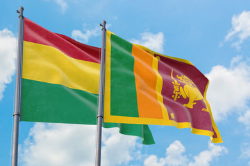 Sri Lanka and Bolivia flags waving in the wind against white cloudy blue sky together. Diplomacy concept, international relations.