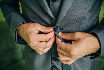 A man fastens a button on a jacket