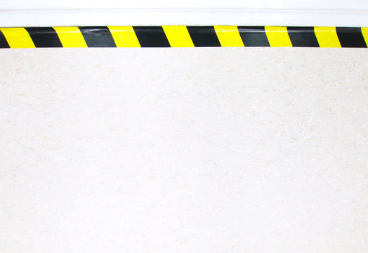 Warning hazard construction stripes sign or symbol texture isolated in granite concrete floor background, for safety first in laboratory walk way to watch out your step. Workplace safety concepts.