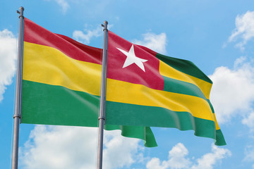 Togo and Bolivia flags waving in the wind against white cloudy blue sky together. Diplomacy concept, international relations.
