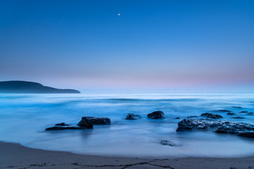 Fototapeta na wymiar Iridescent Blue Dawn Seascape with Crescent Moon