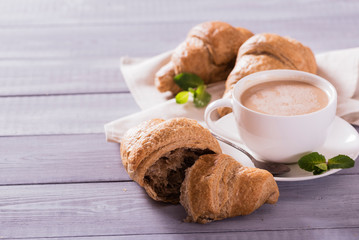 breakfast with fresh croissants and coffee on wooden table