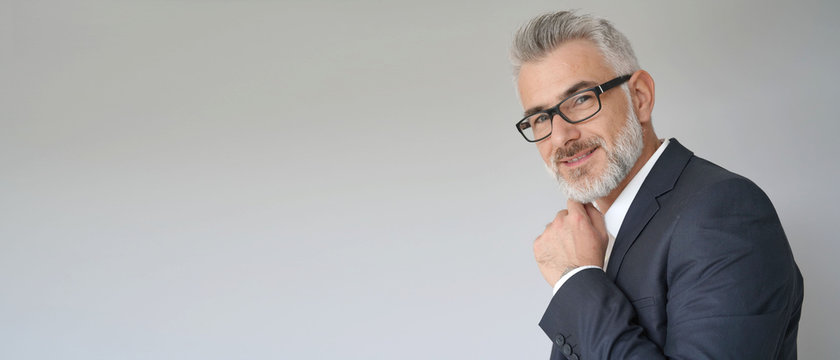 Portrait of businessman standing on grey background - template