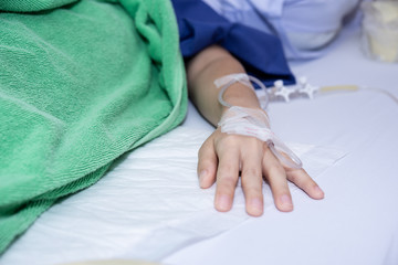 A saline tube for patient in the hospital.Close up of saline drip in patient's hand . Asian woman with hospital admission, Copy space