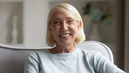 Headshot portrait of happy mature woman feeling positive