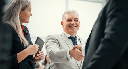 close up. confident business people shaking hands with each other.