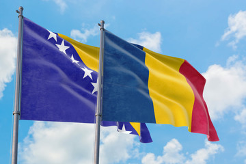 Chad and Bosnia Herzegovina flags waving in the wind against white cloudy blue sky together. Diplomacy concept, international relations.