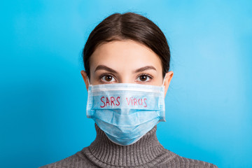 Portrait of a woman in medical mask with SARS virus text at blue background. Coronavirus concept. Respiratory protection