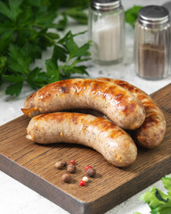 Grilled sausages on a wooden Board on a light gray kitchen table