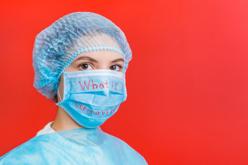 Portrait of a woman wearing medical uniform and mask with what is coronavirus word at red background. Coronavirus concept. Respiratory protection concept with copy space