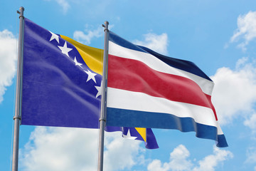 Costa Rica and Bosnia Herzegovina flags waving in the wind against white cloudy blue sky together. Diplomacy concept, international relations.