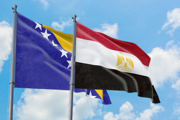 Egypt and Bosnia Herzegovina flags waving in the wind against white cloudy blue sky together. Diplomacy concept, international relations.