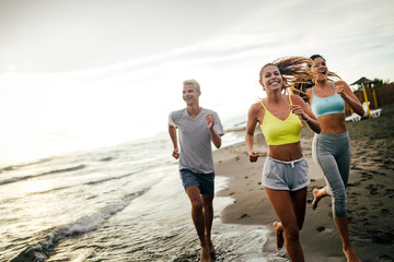 Group of sport people running on the beach