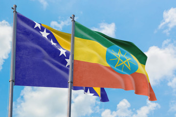 Ethiopia and Bosnia Herzegovina flags waving in the wind against white cloudy blue sky together. Diplomacy concept, international relations.