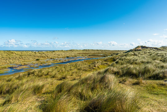 Sand dunes, rain water puddles near Norfolk Coast path National Trail