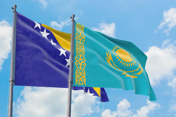 Kazakhstan and Bosnia Herzegovina flags waving in the wind against white cloudy blue sky together. Diplomacy concept, international relations.