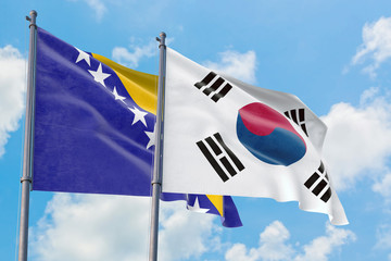 South Korea and Bosnia Herzegovina flags waving in the wind against white cloudy blue sky together. Diplomacy concept, international relations.