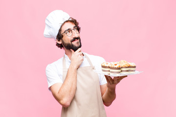 young crazy baker man confectionery concept against pink wall