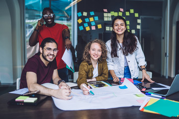 Successful office worker drawing sketch with colleagues