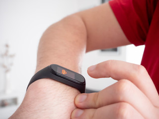 A man wears a fitness bracelet on his hand. Using a pedometer. Electronics for measuring heart rate.