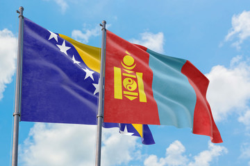 Mongolia and Bosnia Herzegovina flags waving in the wind against white cloudy blue sky together. Diplomacy concept, international relations.