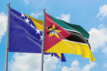 Mozambique and Bosnia Herzegovina flags waving in the wind against white cloudy blue sky together. Diplomacy concept, international relations.