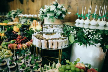 Wedding table with appetizers and fruits and desserts at the ceremony, catering