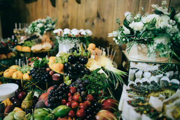 Wedding table with appetizers and fruits and desserts at the ceremony, catering