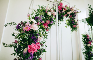 Fototapeta na wymiar Lovely wedding arch made of fresh purple and pink flowers on wedding reception