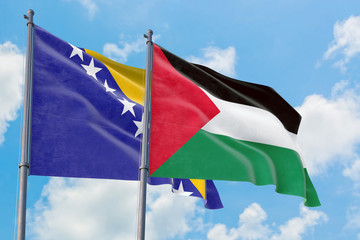 Palestine and Bosnia Herzegovina flags waving in the wind against white cloudy blue sky together. Diplomacy concept, international relations.