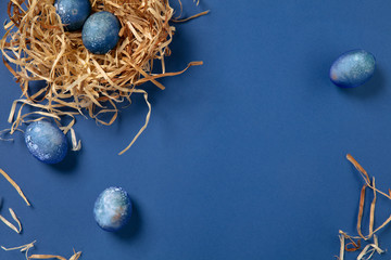 Egg hunt is coming. Easter traditions, space, cosmos colored eggs on blue background, top view, copyspace for ad or greetings. Concept of holidays, spring, celebrating, food and sweets, family time.