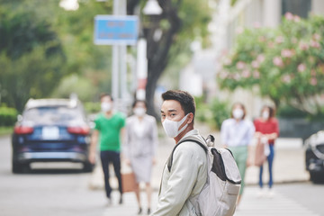 Asian town citizen walking in the street with face mask to protect himself from terminal disease