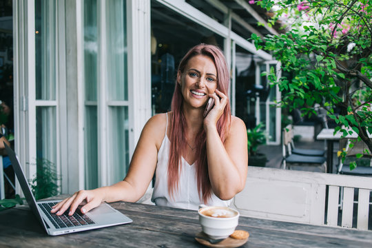 Modern Woman Talking On Phone While Woking On Laptop