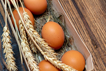 farm brown eggs with straw in birch bark box wooden background close-up