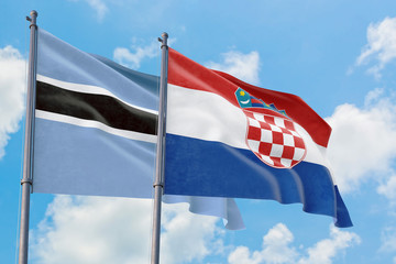 Croatia and Botswana flags waving in the wind against white cloudy blue sky together. Diplomacy concept, international relations.
