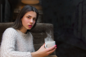 girl in a cafe drinks hot coffee