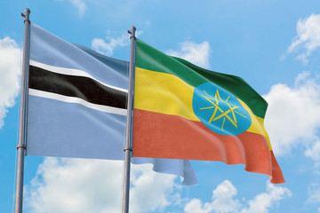 Ethiopia and Botswana flags waving in the wind against white cloudy blue sky together. Diplomacy concept, international relations.