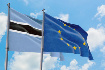 European Union and Botswana flags waving in the wind against white cloudy blue sky together. Diplomacy concept, international relations.